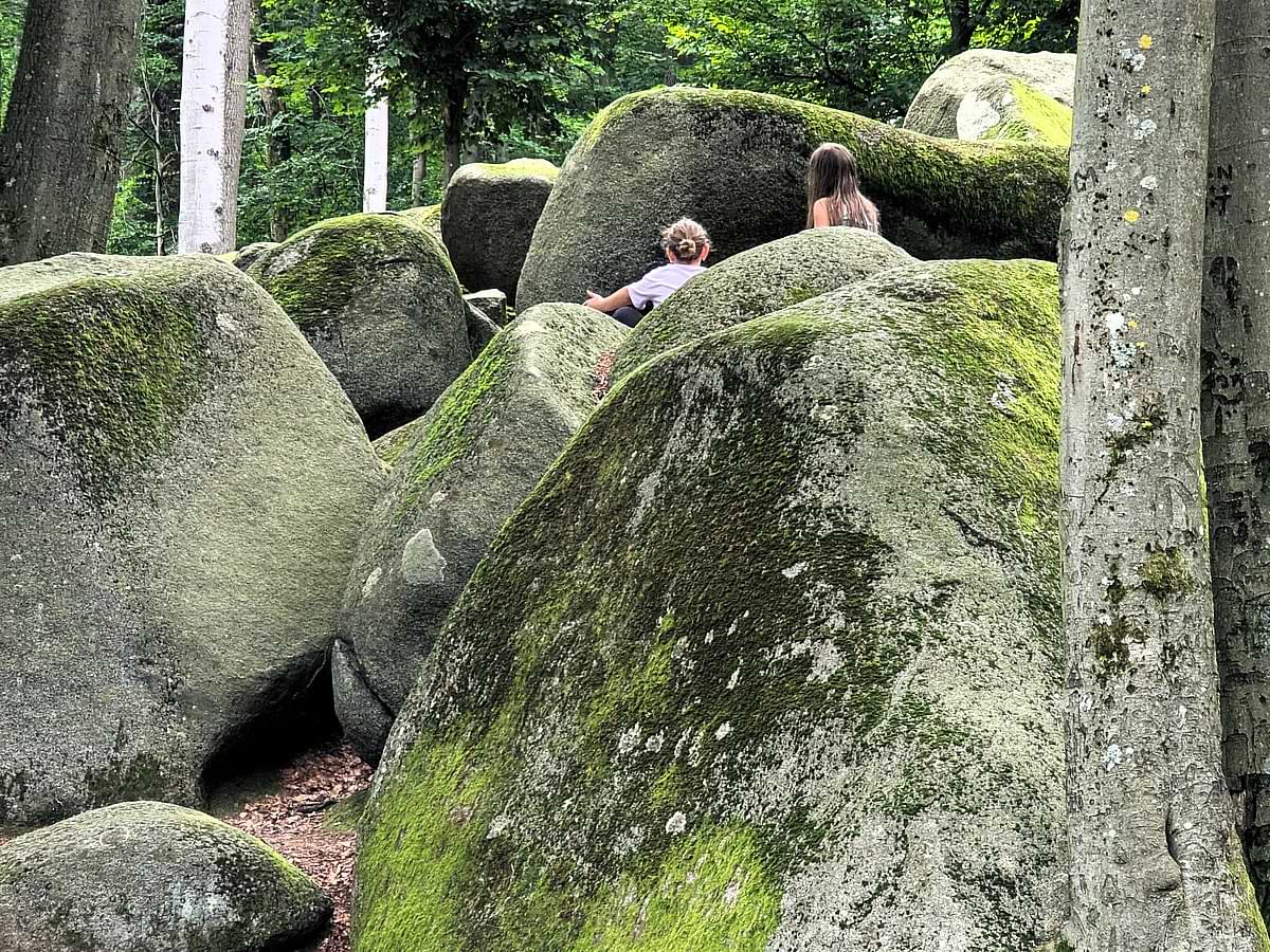 Kinder beim Spielen und Klettern zwischen den Felsen