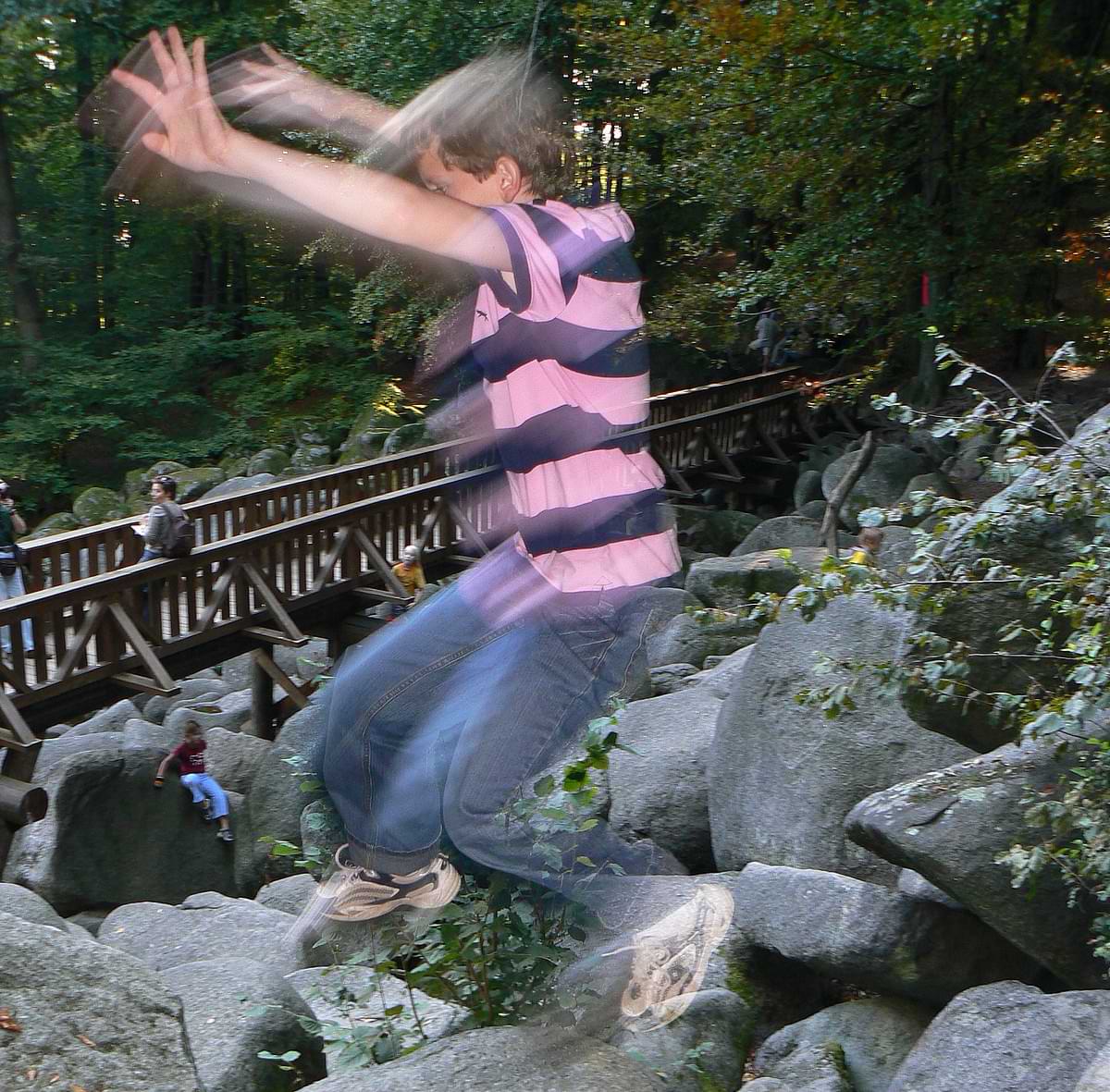 Kind springt spielerisch von einem Granitblock zum nächsten