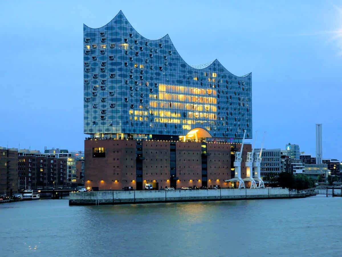 Die Elbphilharmonie bei Nacht – ein atemberaubender Anblick, wenn die gläserne Fassade golden leuchtet und sich im Wasser spiegelt.
