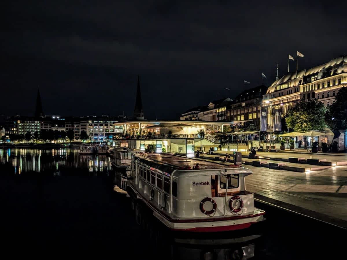 Der Jungfernstieg bei Nacht, wenn die Lichter der Stadt das Wasser zum Glitzern bringen.