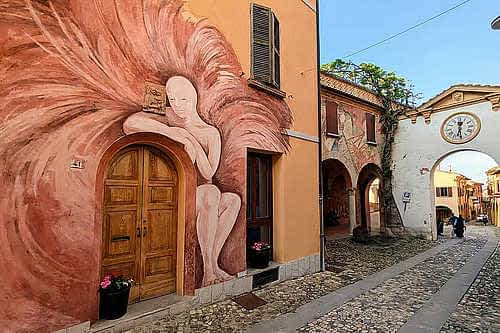 Manchmal sind es die Orte, die man gar nicht groß auf dem Schirm hat, die am meisten überraschen. Genau so ging es uns mit Dozza, einem kleinen Dorf in den Hügeln der Emilia-Romagna, das mit seinen bemalten Fassaden einer Kunstagalerie gleicht. 