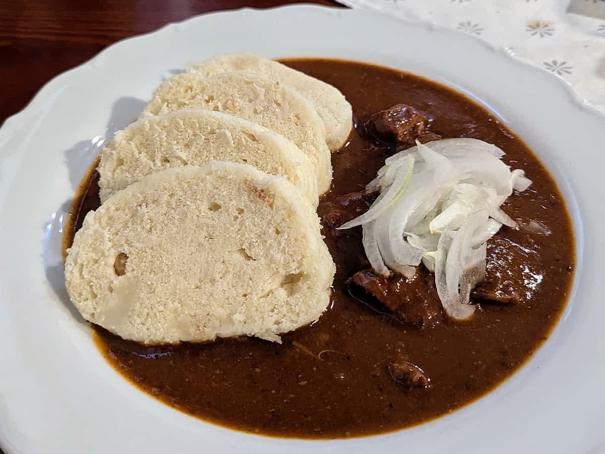 eller mit tschechischem Rindergulasch, Soße und Knödeln, serviert in einem traditionellen Restaurant in Karlsbad