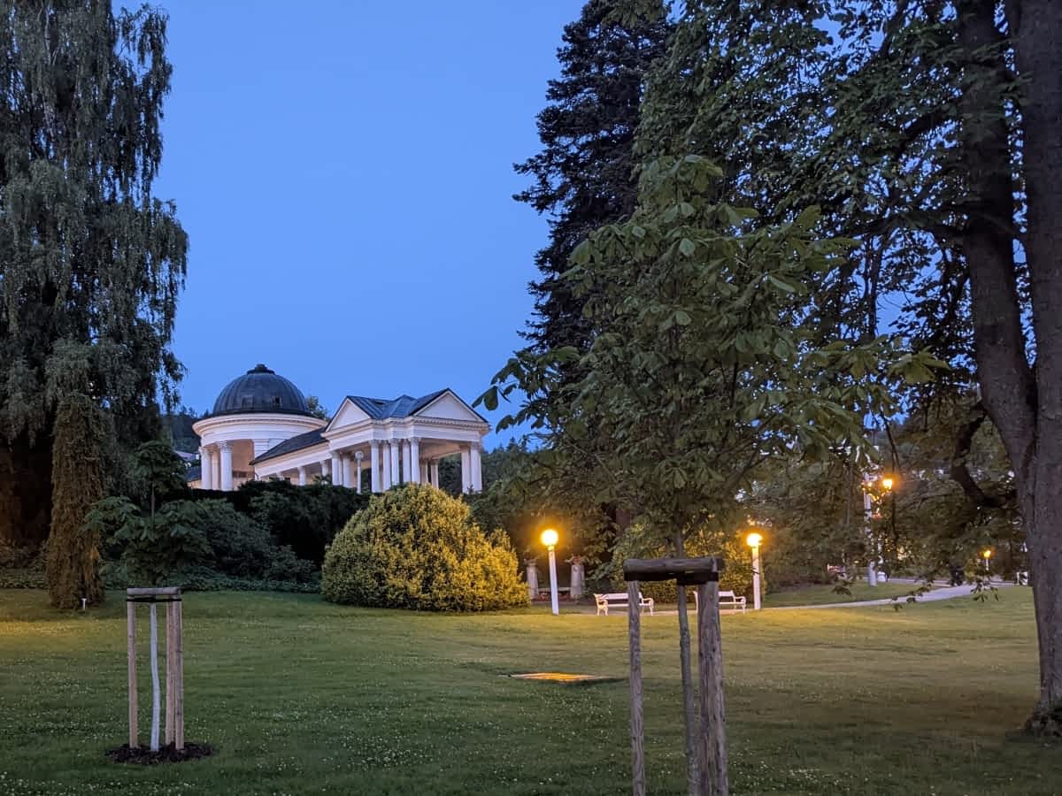 Karolinaquelle in Marienbad, umgeben vom gepflegten Kurpark mit Wegen und Bäumen